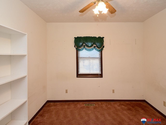 carpeted spare room with a textured ceiling and ceiling fan