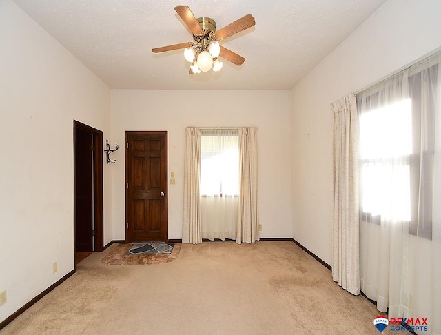 carpeted empty room featuring a textured ceiling and ceiling fan