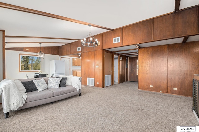 carpeted living room with wooden walls, lofted ceiling with beams, and a chandelier