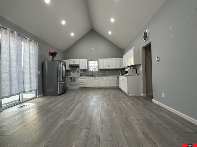 kitchen featuring white cabinets, light hardwood / wood-style flooring, stainless steel fridge, high vaulted ceiling, and electric stove