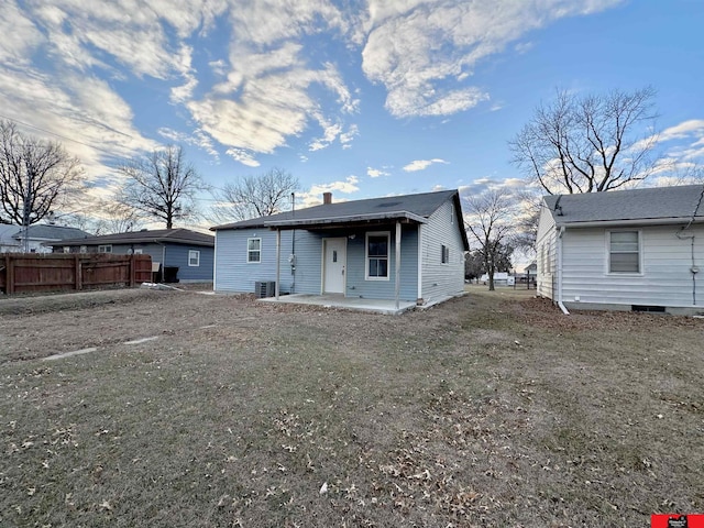 rear view of house with a patio, central AC, and a lawn