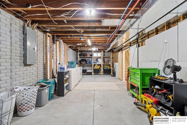 basement with washer and dryer, brick wall, and electric panel