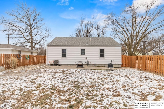 snow covered back of property featuring cooling unit and a patio area