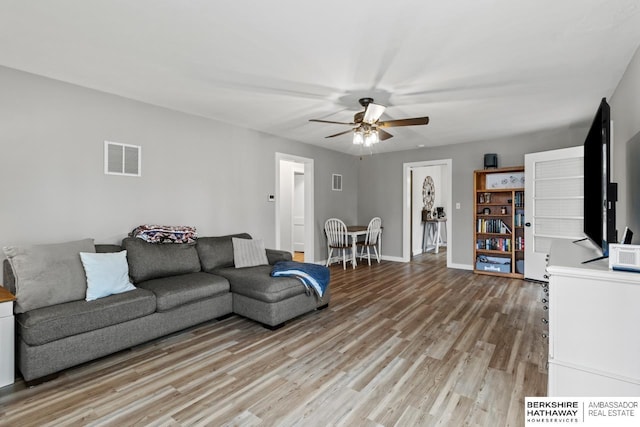 living room with ceiling fan and light hardwood / wood-style flooring