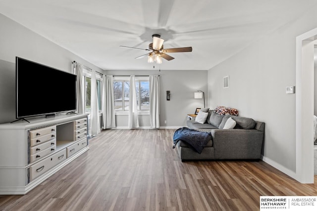 living room featuring ceiling fan and wood-type flooring