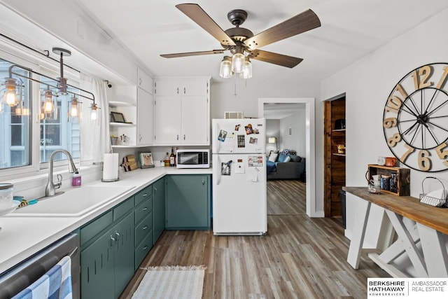 kitchen featuring stainless steel dishwasher, decorative light fixtures, white cabinetry, white refrigerator, and sink