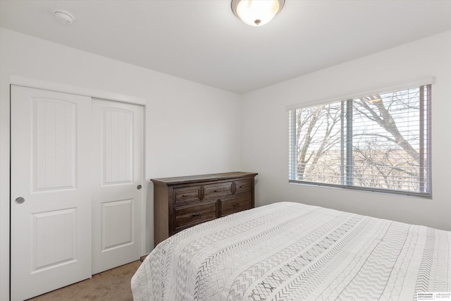 bedroom featuring a closet and light colored carpet