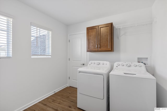 washroom featuring dark hardwood / wood-style flooring, separate washer and dryer, and cabinets