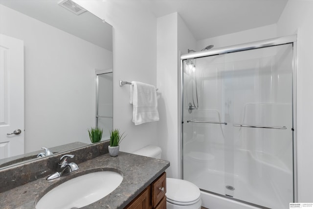 bathroom with toilet, vanity, and an enclosed shower