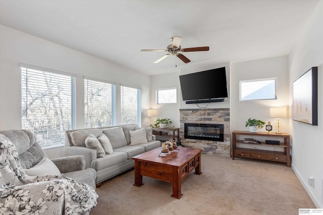 carpeted living room with ceiling fan, a healthy amount of sunlight, and a fireplace