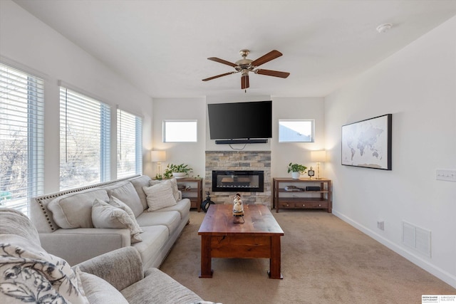 carpeted living room with ceiling fan and a fireplace