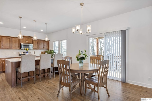 dining space featuring light hardwood / wood-style floors and a chandelier