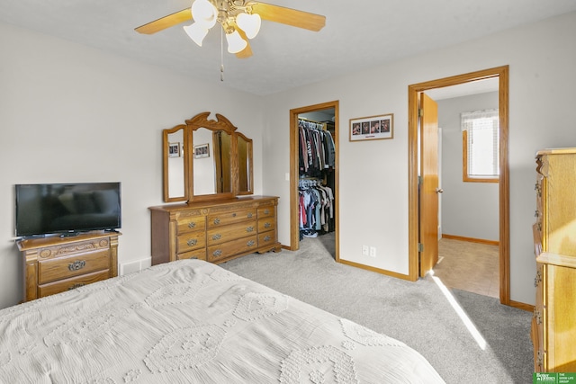 carpeted bedroom featuring ceiling fan, a spacious closet, and a closet