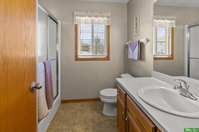 bathroom with walk in shower, a wealth of natural light, vanity, and toilet