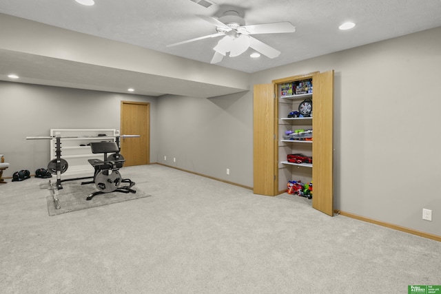 exercise room with light colored carpet and ceiling fan