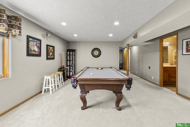 recreation room with billiards, a textured ceiling, and light colored carpet