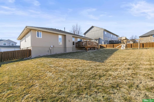 back of house featuring a deck and a yard