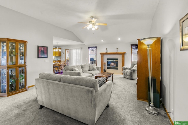 living room featuring light colored carpet, lofted ceiling, and ceiling fan with notable chandelier