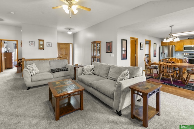 living room featuring ceiling fan with notable chandelier