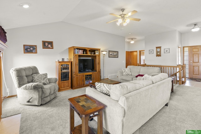 carpeted living room with ceiling fan and vaulted ceiling