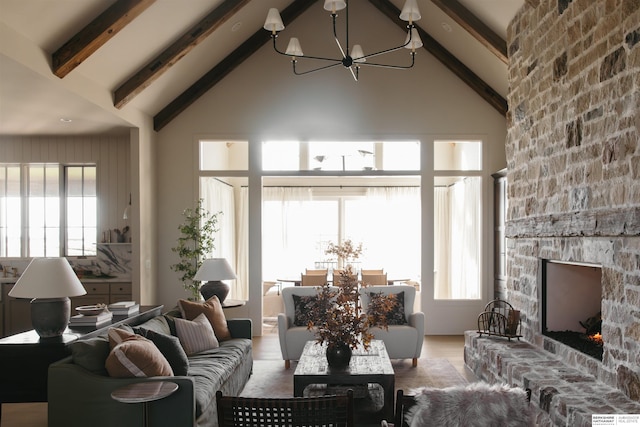 living room with beamed ceiling, a chandelier, high vaulted ceiling, and a fireplace