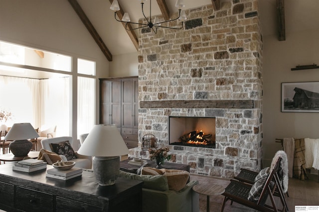 living room with a stone fireplace, wood-type flooring, beamed ceiling, a notable chandelier, and high vaulted ceiling