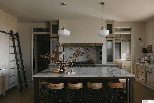 kitchen featuring a breakfast bar, decorative backsplash, and pendant lighting