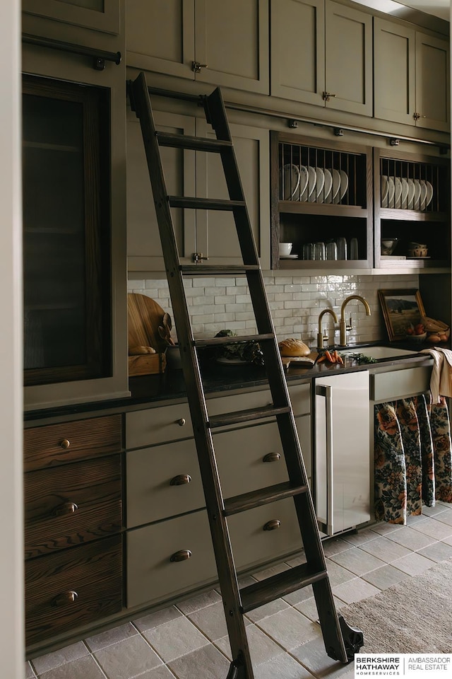 interior space with fridge, backsplash, and sink