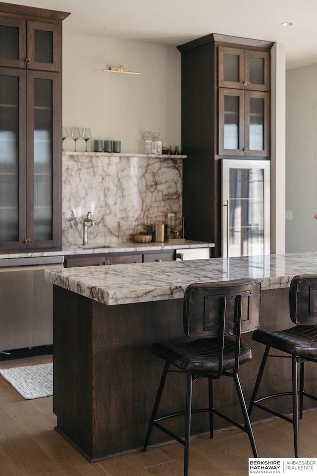 bar with dark hardwood / wood-style floors, decorative backsplash, and sink