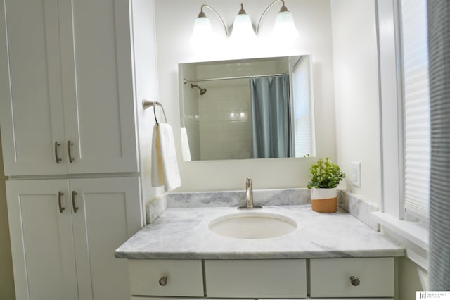 bathroom featuring curtained shower and vanity