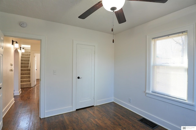 unfurnished bedroom featuring dark hardwood / wood-style flooring, a closet, and ceiling fan