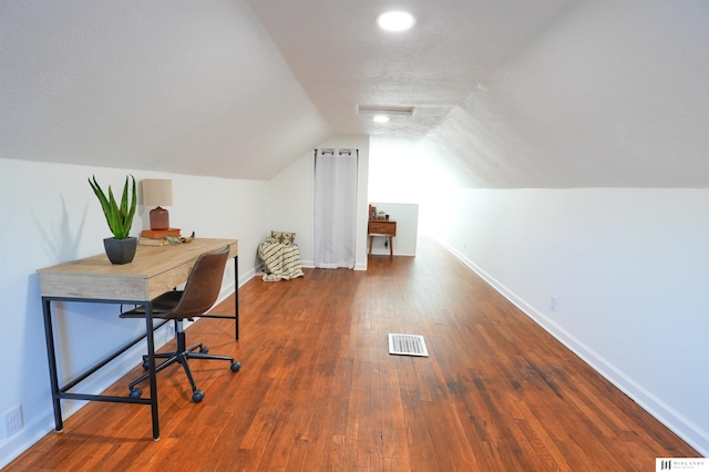 office area featuring a textured ceiling, dark wood-type flooring, and vaulted ceiling