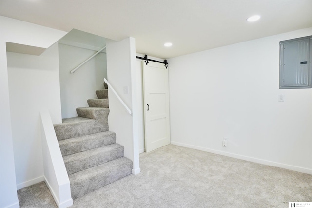 stairway featuring electric panel, carpet floors, and a barn door