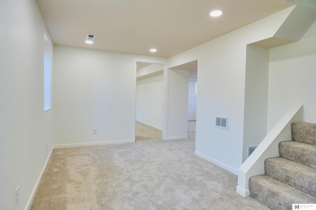 basement featuring light colored carpet