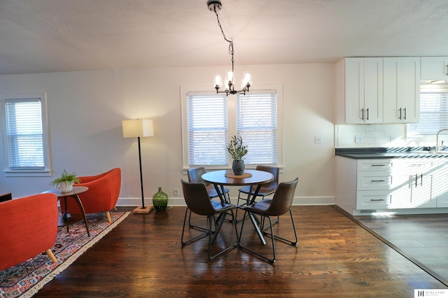 dining room featuring dark wood-type flooring, a chandelier, and plenty of natural light