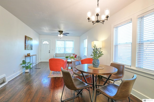 dining area featuring a healthy amount of sunlight, dark hardwood / wood-style flooring, and ceiling fan with notable chandelier