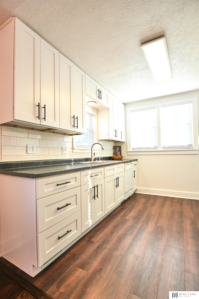 kitchen featuring white cabinets, backsplash, and sink