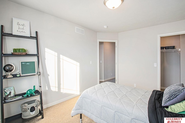 bedroom featuring a spacious closet, a closet, and carpet flooring