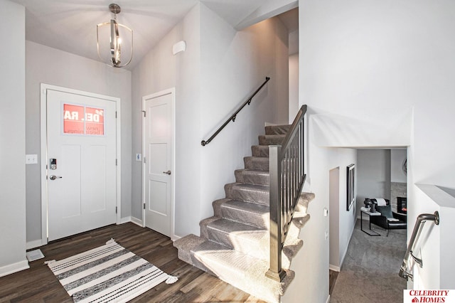 foyer entrance with dark wood-type flooring and an inviting chandelier