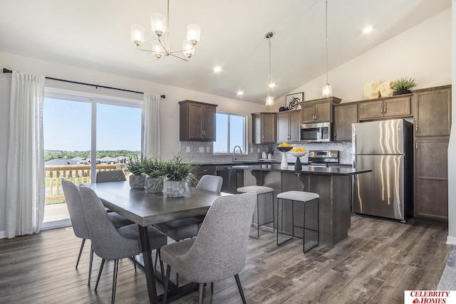 dining space featuring sink, high vaulted ceiling, a notable chandelier, and dark hardwood / wood-style floors