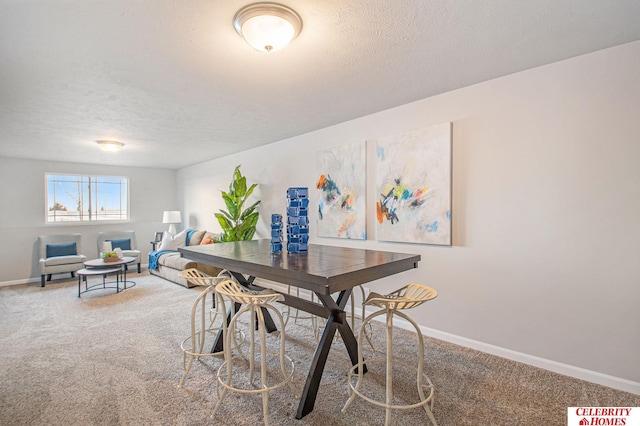 carpeted dining area featuring a textured ceiling