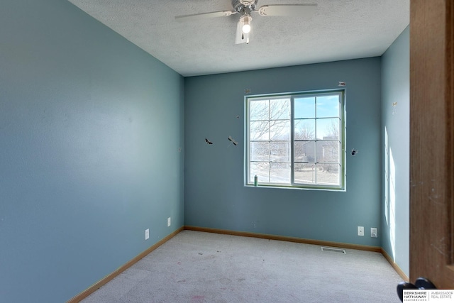 empty room featuring a textured ceiling, ceiling fan, and light colored carpet