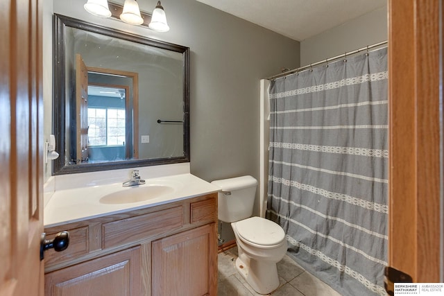 bathroom featuring toilet, tile patterned flooring, vanity, and curtained shower