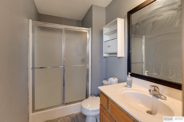 bathroom with a shower with shower door, vanity, toilet, and hardwood / wood-style flooring