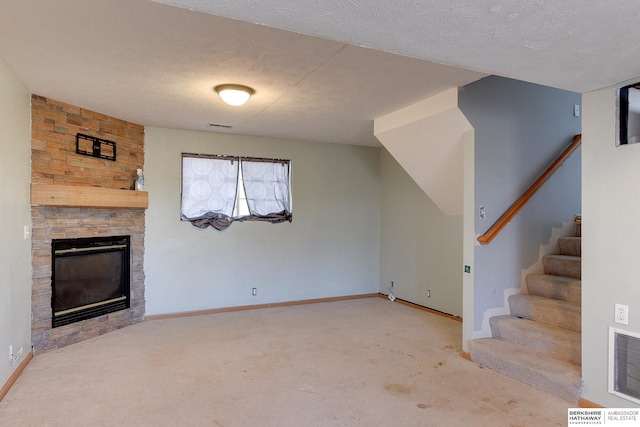 unfurnished living room featuring light colored carpet, a fireplace, and a textured ceiling