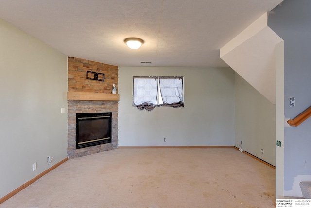 unfurnished living room with light colored carpet, a textured ceiling, and a fireplace