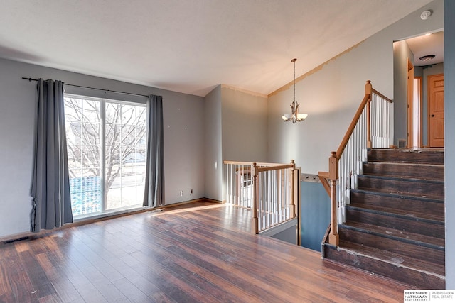 interior space featuring hardwood / wood-style flooring, lofted ceiling, and a notable chandelier