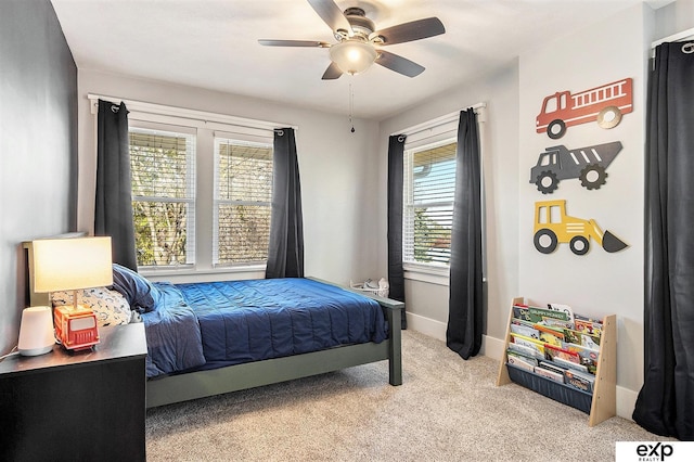 bedroom featuring multiple windows, light carpet, and ceiling fan