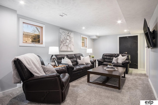 carpeted living room featuring a textured ceiling