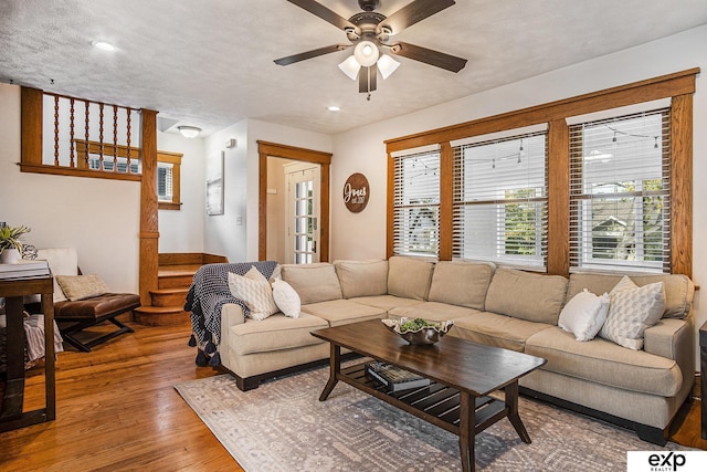 living room with wood-type flooring and ceiling fan